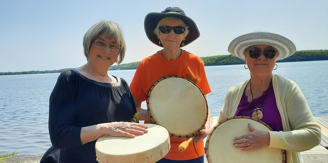 Three women holding drums